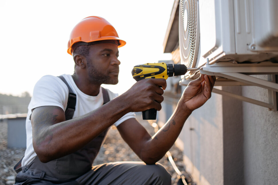 HVAC technician working on AC unit