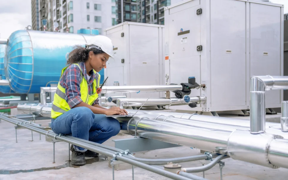 woman wearing a safety vest is engaged in pipe maintenance